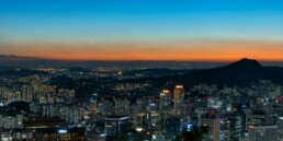 Seoul apartment skyline at dusk showing high-rise residential buildings along the Han River representing the Korea housing crisis 2026