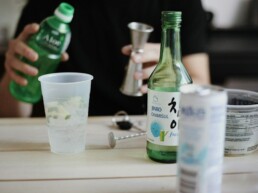 Green soju bottle and shot glass on a Korean dining table — Korea soju industry 2026