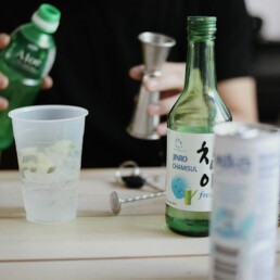 Green soju bottle and shot glass on a Korean dining table — Korea soju industry 2026